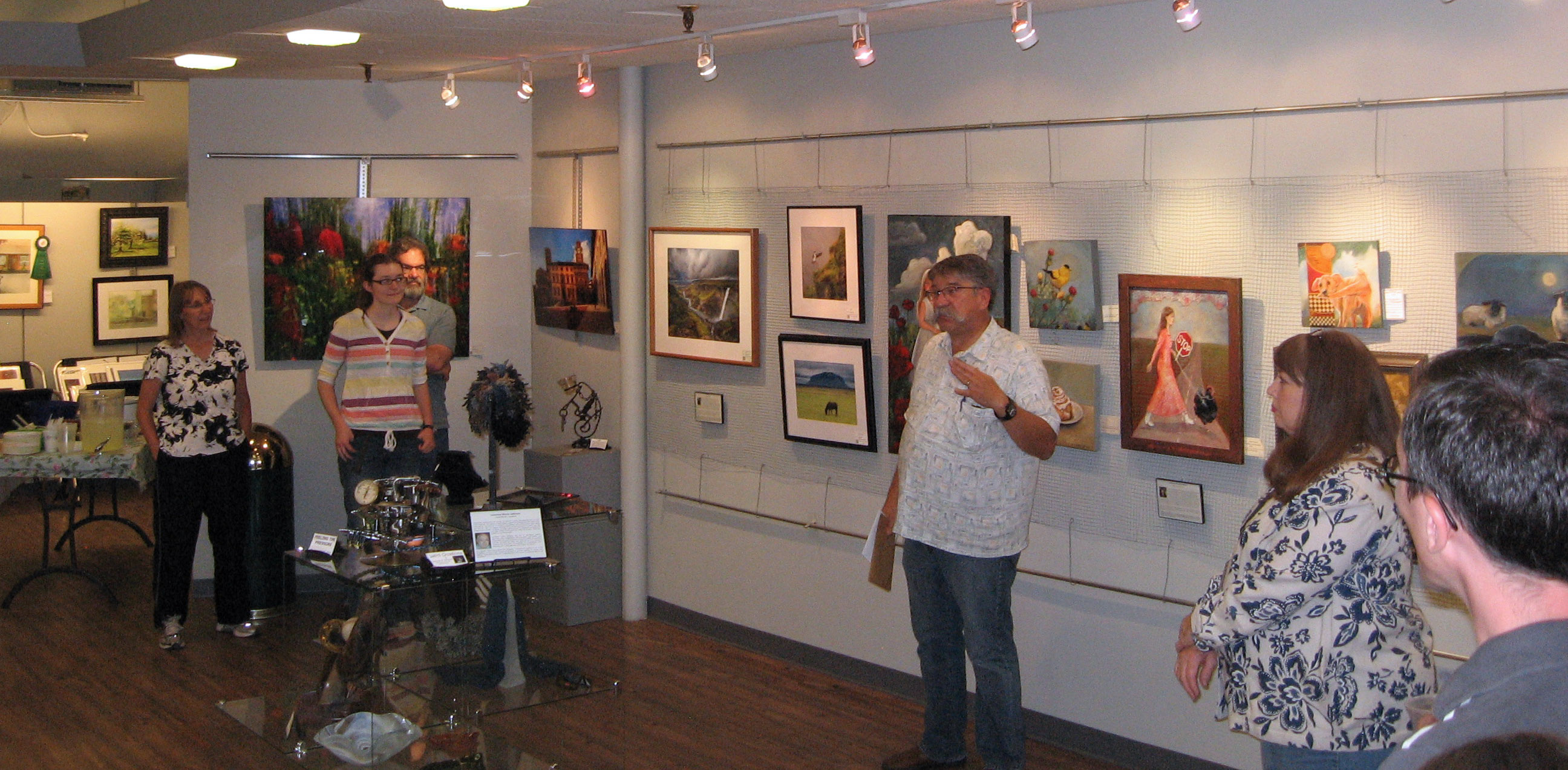 A crowd inside the gallery, all focused on artist Blaine Clayton.